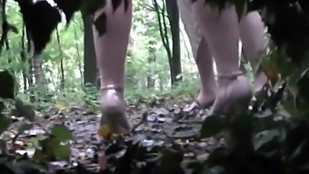 Voyeur is spying and recording two girl pissing in the wood